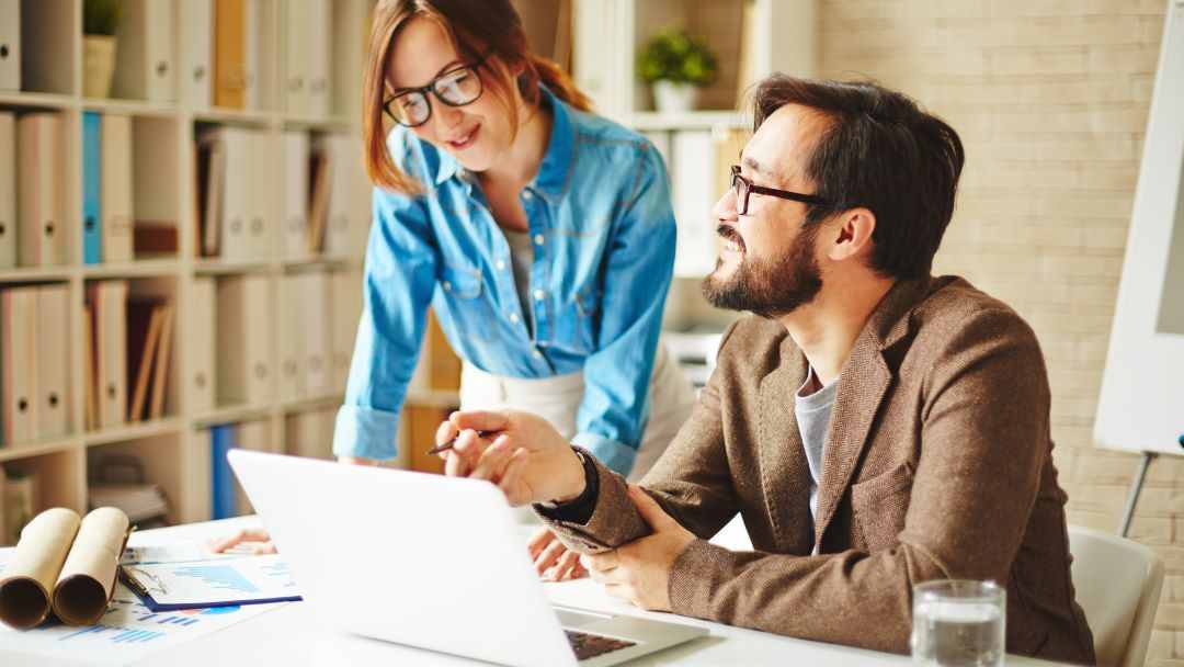 Two business associates talking together at  desk