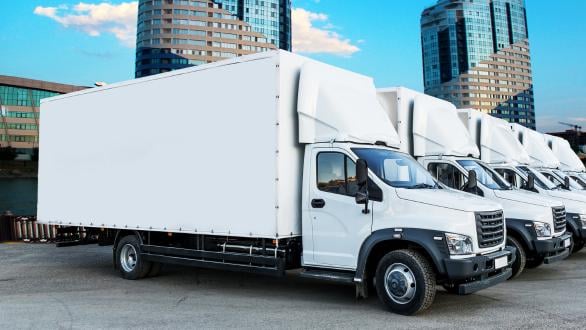 White trucks lined up in a parking lot. 